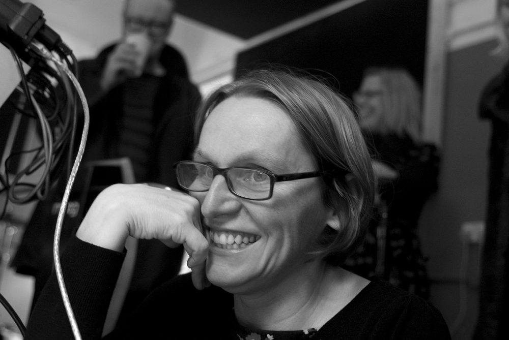 Sarah Angliss, smiling, in a rehearsal room